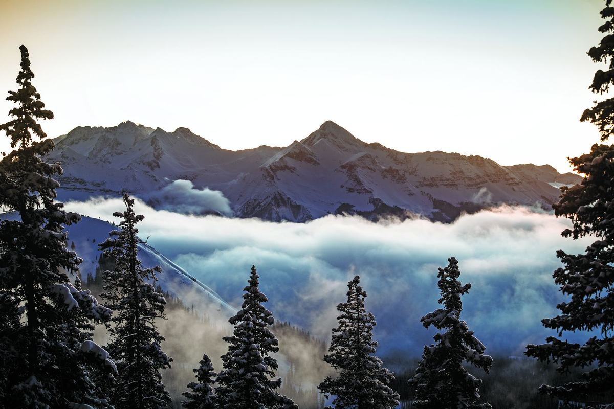 Peaks catching first light above a sea of cloud, seen from 11,966 feet on Gold Hill at Telluride Ski Resort