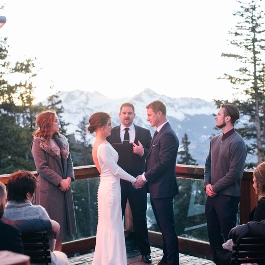 A couple exchanging vows on the Alpino Vino deck at sunset, Mount Wilson behind them at 11,966 feet above Telluride