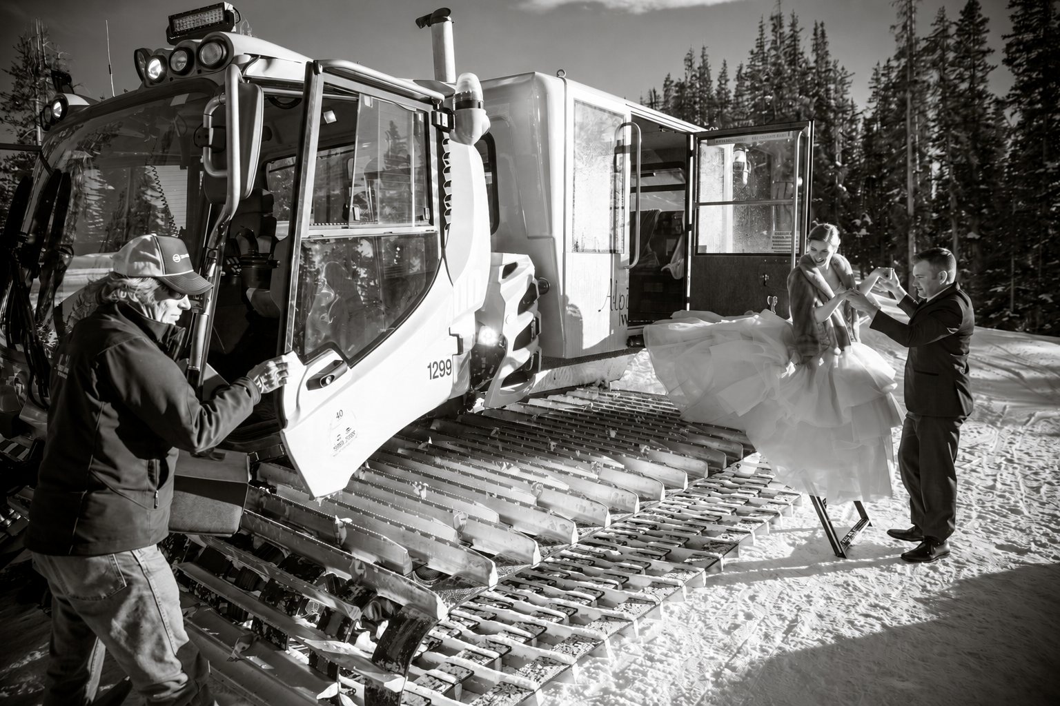 A bride stepping down from the Alpino Vino snowcoach in her wedding dress, helped by the groom and the driver, at 11,966 feet above Telluride
